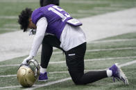 Washington linebacker Daniel Heimuli kneels on the turf at the start of NCAA college football practice, Friday, Oct. 16, 2020, in Seattle. (AP Photo/Ted S. Warren)