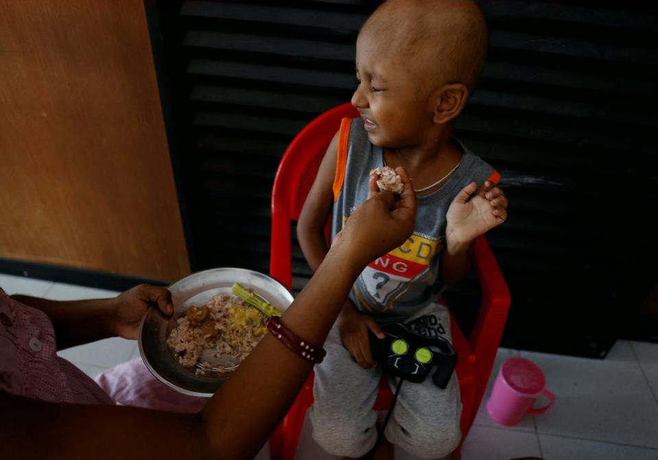 Sathiyaraj Silaskana attempts to feed her son (Reuters)