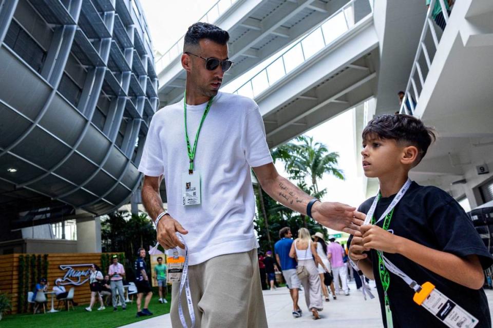 Inter Miami player Sergio Busquets interacts with his son Enzo, 7, as they walk through the paddock during day one of Formula One Miami Grand Prix.