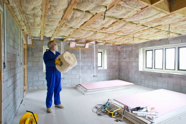 BECTMP Man holding ceiling insulation in house under construction