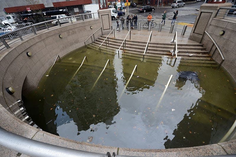 People take photos of water filling the entrance of The Plaza Shops in Battery Park in New York on October 30, 2012 as New Yorkers cope with the aftermath of Hurricane Sandy. 