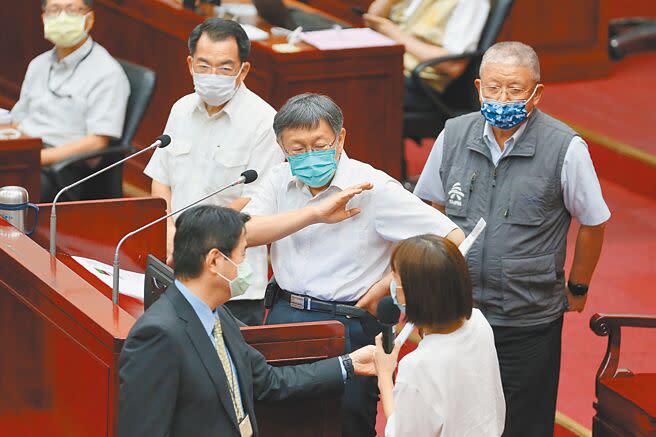 台北市長柯文哲（中）6日在市議會備詢，市議員林穎孟（右下）拿著「捍衛台灣 絕不投降 承諾書」要給柯文哲簽署。（本報資料照片）
