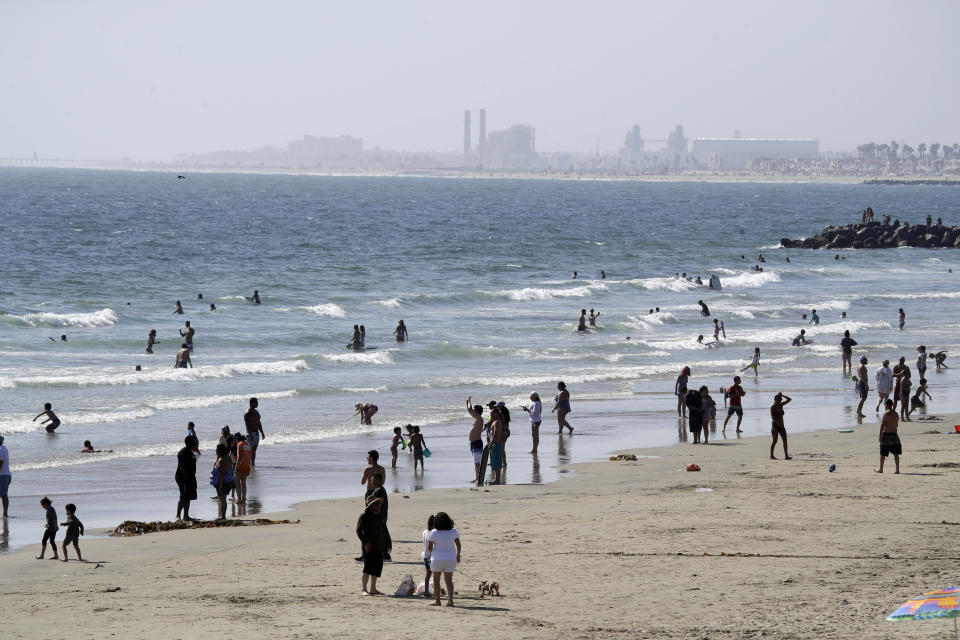 FILE - In this May 24, 2020 file photo, people visit the beach in Newport Beach, Calif., during the coronavirus pandemic. Beachgoers are being urged to practice social distancing to guard against COVID-19. (AP Photo/Marcio Jose Sanchez, File)