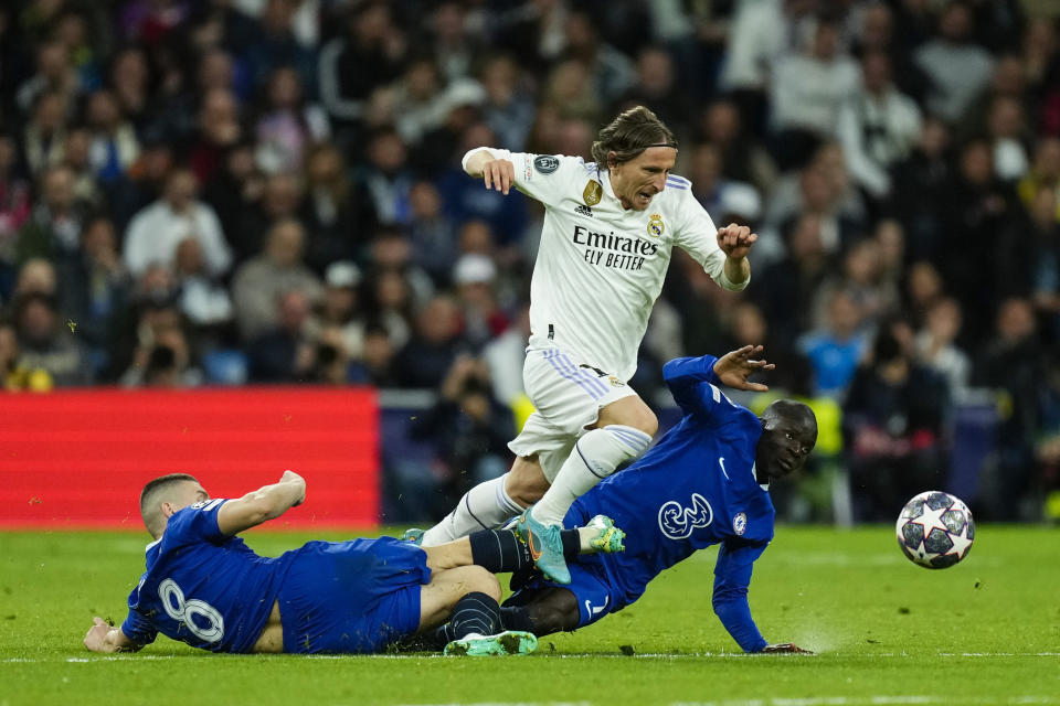 Real Madrid's Luka Modric, top, vies for the ball with Chelsea defenders during the Champions League quarter final first leg soccer match between Real Madrid and Chelsea at Santiago Bernabeu stadium in Madrid, Wednesday, April 12, 2023. (AP Photo/Jose Breton)