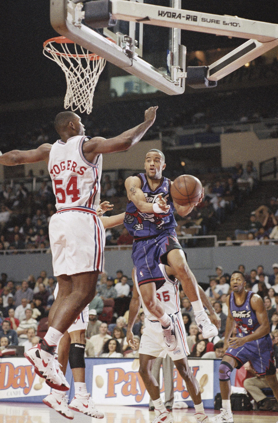 FILE - Toronto Raptors' Damon Stoudamire takes to the air against Los Angeles Clippers' Rodney Rogers in first period NBA action on Feb. 3, 1996, at the Sports Arena in Los Angeles. The longtime NBA guard Stoudamire was hired Monday, March 13, 2023, as Georgia Tech's men's basketball coach. (AP Photo/Michael Tweed, File)