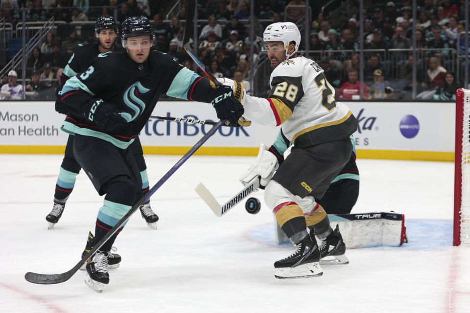 Vegas Golden Knights left wing William Carrier (28) and Seattle Kraken defenseman Will Borgen compete for the puck in front of Kraken goaltender Martin Jones during the first period of an NHL hockey game Saturday, Oct. 15, 2022, in Seattle. (AP Photo/Jason Redmond)