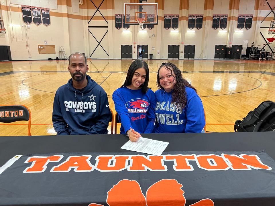 Taunton's Nia Mainer-Smith (center) signs her National Letter of Intent committing to UMass Lowell alongside father Jamal Mainer-Smith (left) and mother Milagros Mainer-Smith (right).