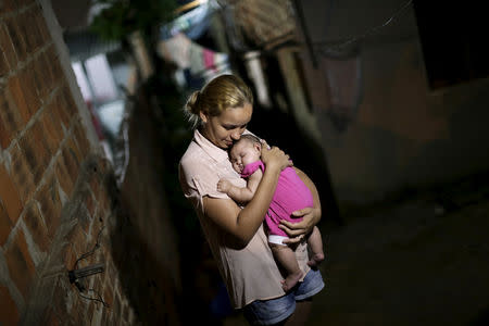 Gleyse Kelly da Silva embraces her daughter Maria Giovanna, who has microcephaly, in Recife, Brazil, January 25, 2016. REUTERS/Ueslei Marcelino/Files