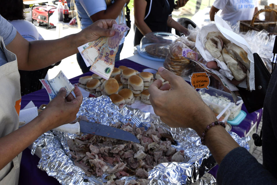 Integrantes de grupos de trabajadores participan en una feria organizada por organismos sociales para vender productos frescos a bajos precios como protesta contra las medidas económicas del presidente Javier Milei, frente al Congreso Nacional, el jueves 21 de diciembre de 2023, en Buenos Aires, Argentina. (AP Foto/Gustavo Garello)