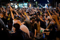 Demonstrators raise their fists as they sit in silence for nine minutes in a peaceful protest against the death in Minneapolis police custody of George Floyd, at 19th and Broadway in Denver, Colorado, U.S., June 1, 2020. Picture taken June 1, 2020. REUTERS/Alyson McClaran