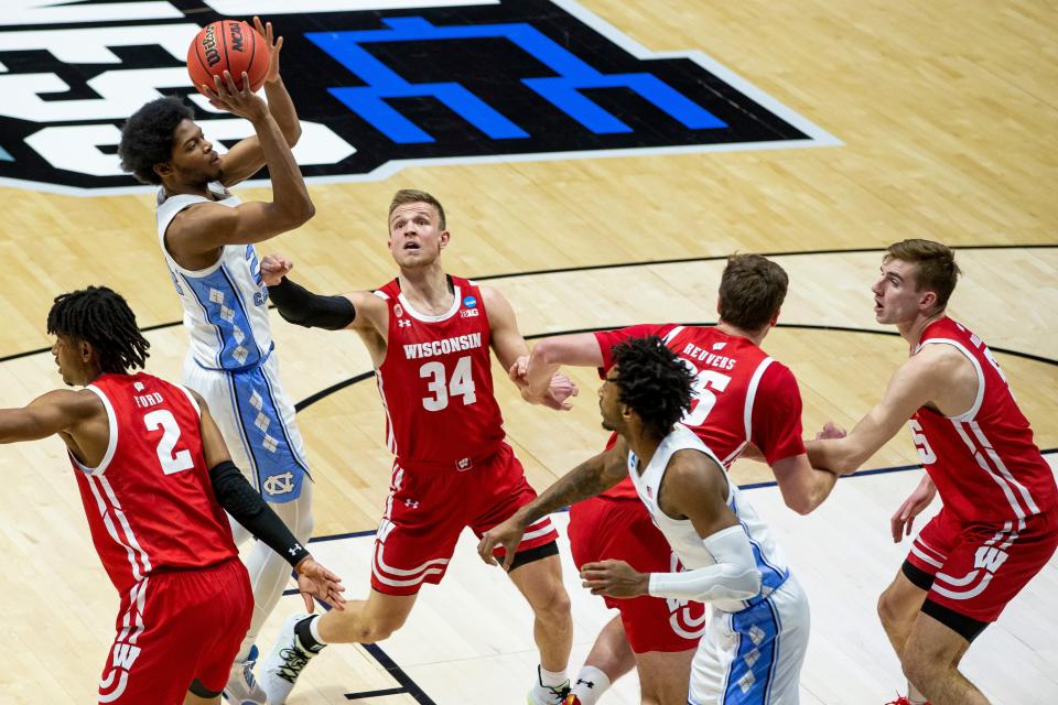 North Carolina's Kerwin Walton, second from left, shoots between Wisconsin's Aleem Ford (2) and Brad Davison (34) during the first half of a first-round game in the NCAA men's college basketball tournament, Friday, March 19, 2021, at Mackey Arena in West Lafayette, Ind.