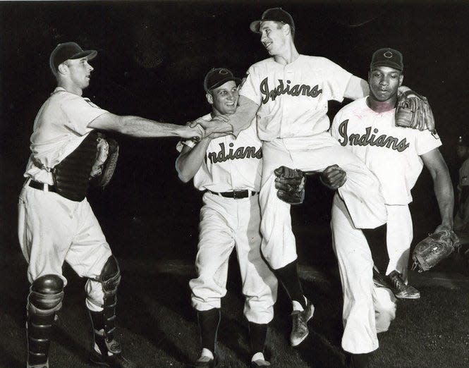 Photo taken August 1951. Backstop Jim Hegan congratulates teammate Bob Feller as he is carried from field by Al Rosen and Luke Easter after Bob shut out Senators 6-0 for his 20th win of the year.