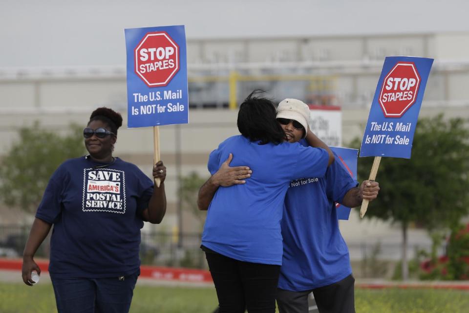 Postal workers gather to protest in Dallas, Thursday, April 24, 2014. Thousands of postal workers around the nation are expected to picket outside Staples' stores to protest a pilot program of postal counters in the stores that are staffed with Staples employees. (AP Photo/LM Otero)
