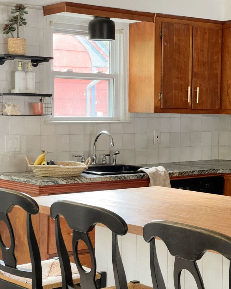 Neutral backsplash in newly renovated kitchen with wooden cabinets.