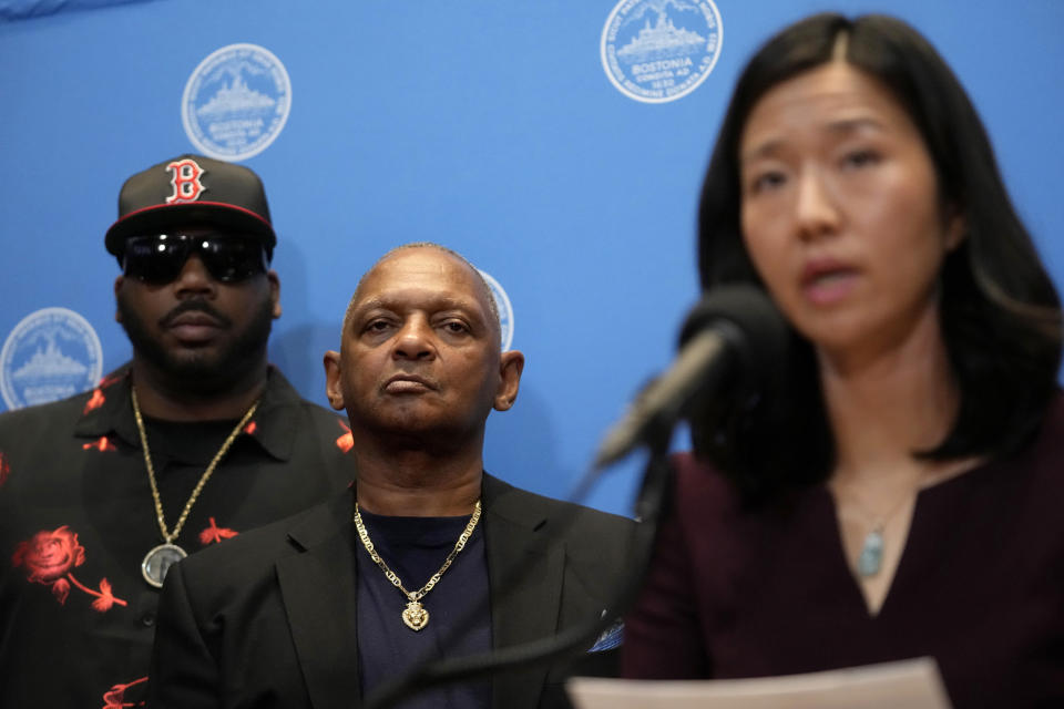 Alan Swanson, center, stands with Boston Mayor Michelle Wu, right, as Wu offers a formal apology to Swanson and Willie Bennett, not shown, during a news conference, Wednesday, Dec. 20, 2023, in Boston. Wu issued a formal apology to Swanson and Bennett Wednesday for their wrongful arrests following the 1989 death of Carol Stuart, whose husband, Charles Stuart, had orchestrated her murder. (AP Photo/Steven Senne)
