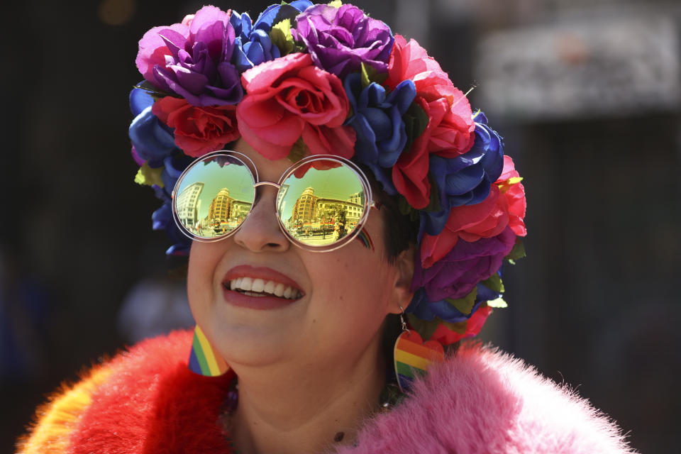 Una persona sonríe mientras los edificios se reflejan en sus anteojos durante la Marcha del Orgullo, el domingo 30 de junio de 2024, en San Francisco. (AP Foto/Ethan Swope)