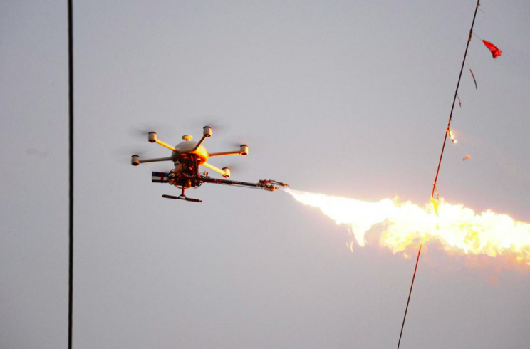 The drones shoot fire at the rubbish that is caught up on power lines (Weibo)