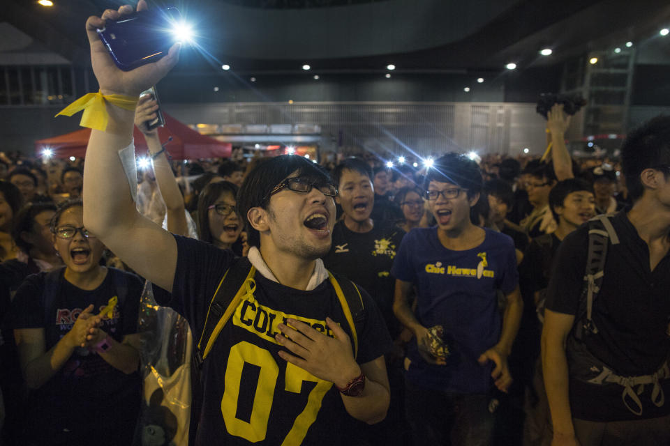 HONG KONG - SEPTEMBER 30: Student protesters shine lights as they chant pro-democracy slogans on the streets on September 30, 2014 in Hong Kong, Hong Kong. Thousands of pro democracy supporters continue to occupy the streets surrounding Hong Kong's Financial district. Protest leaders have set an October 1st deadline for their demands to be met and are calling for open elections and the resignation of Hong Kong's Chief Executive Leung Chun-ying. (Photo by Paula Bronstein/Getty Images)