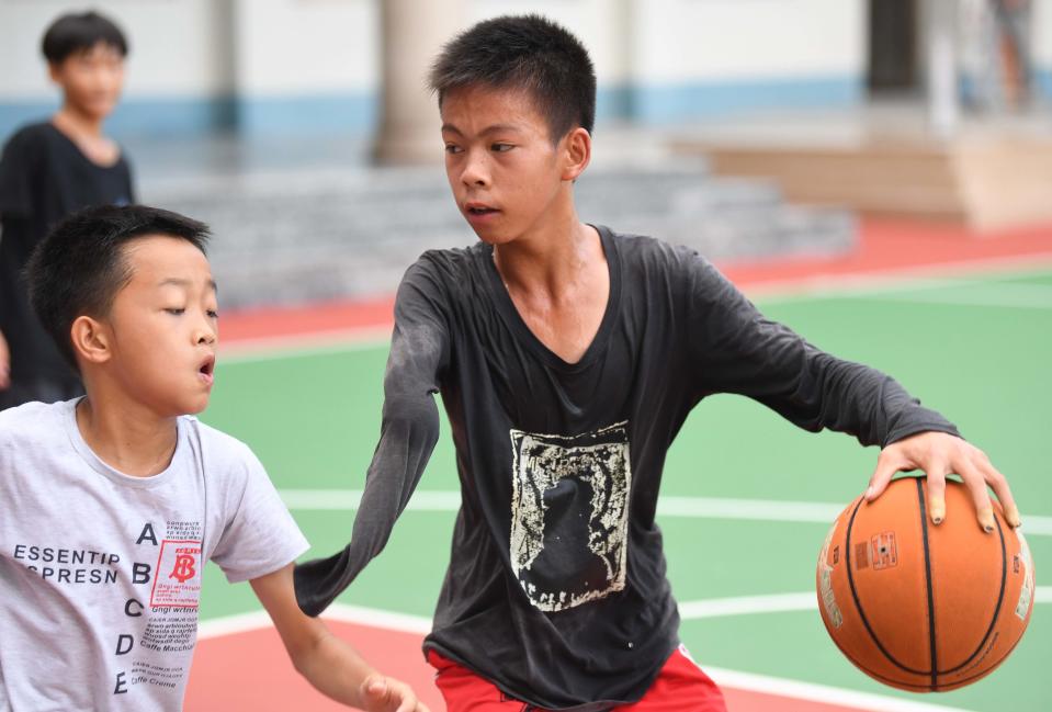 Zhang Jiacheng jugando al baloncesto en la cancha de su colegio. (Foto: Deng Hua / Xinhua / Getty Images).