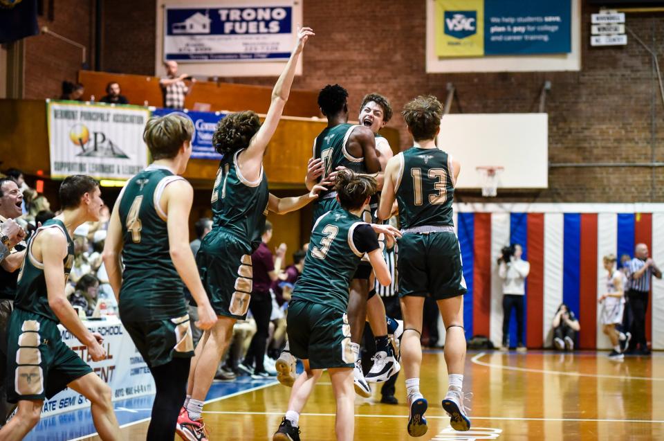 The Montpelier High School boys basketball team celebrates a Division II three-peat championship on Saturday at Barre Auditorium.