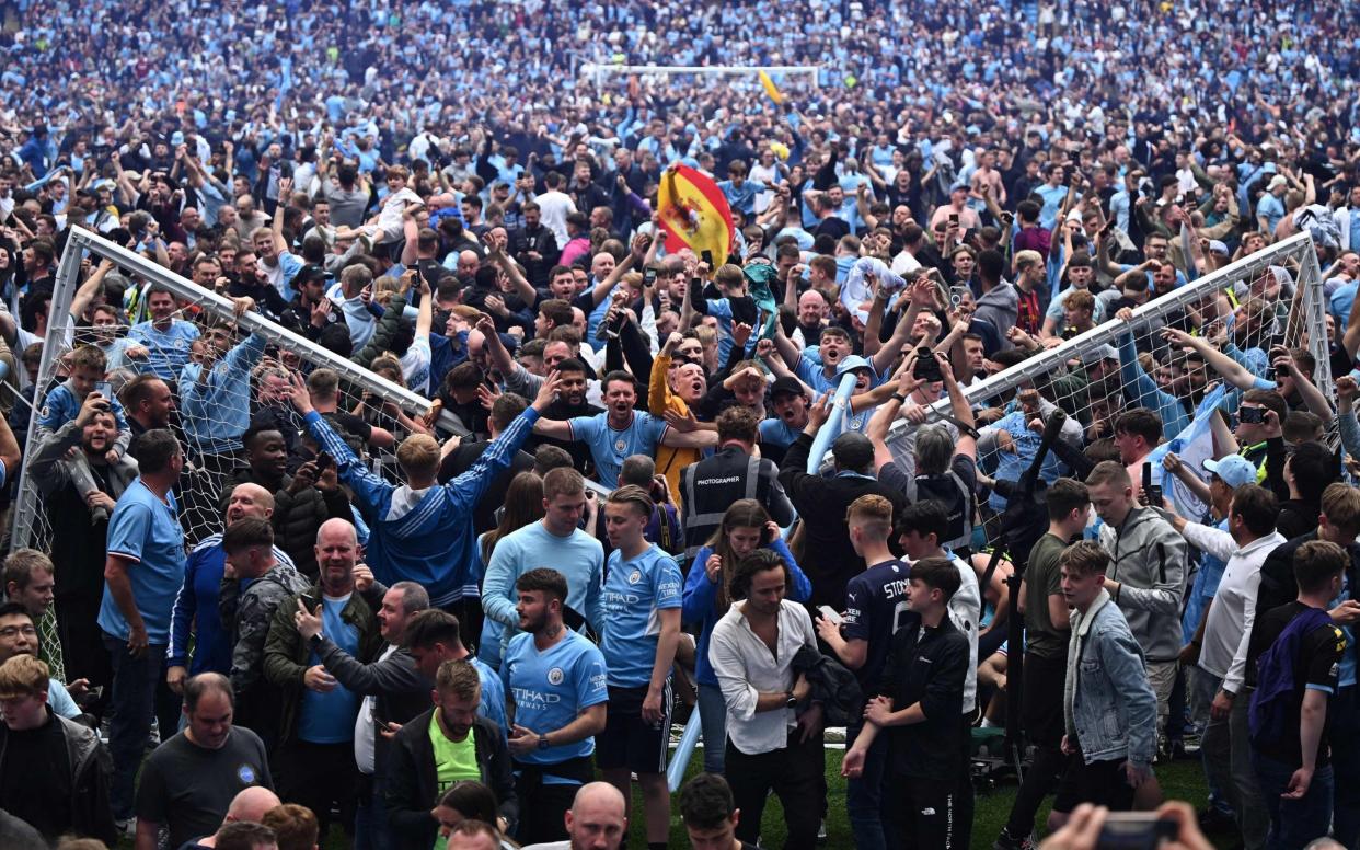 Manchester City's fans celebrate as they invade the pitch at the end of the English Premier League football match - AFP