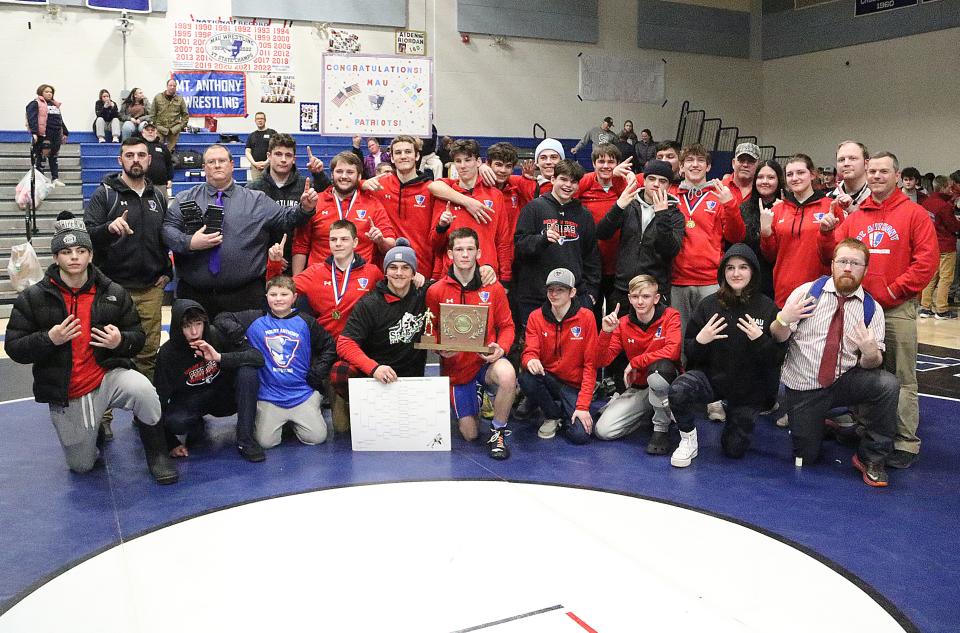 The Mount Anthony wrestling team poses with the State Championship trophy for the 34th year in a row on Saturday at Vergennes High School.