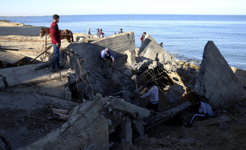 Residents inspect destroyed sewage pipes following overnight Israeli missile strikes along the beach of Shati refugee camp, in Gaza City, Thursday, Feb. 6, 2020. Earlier on Wednesday, Israel struck Hamas militant targets in Gaza in response to rocket fire toward Israeli communities the previous night. (AP Photo/Adel Hana)