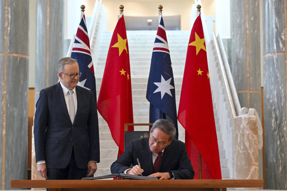 Chinese Premier Li Qiang, right, signs the visitor book as Australia's Prime Minister Anthony Albanese looks on at Parliament House in Canberra, Australia, Monday, June 17, 2024. Li, Albanese and senior ministers of both administrations met at Parliament House on Monday to discuss thorny issues, including lingering trade barriers, conflict between their militaries in international waters and China's desire to invest in critical minerals. (Mick Tsikas/Pool Photo via AP)