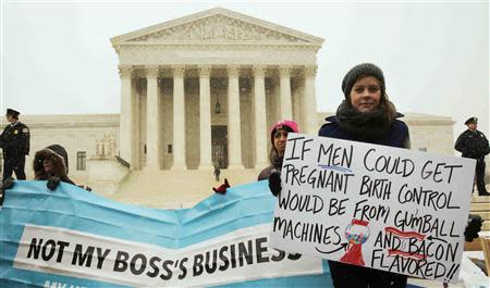 Protester Julia Mitchell holds a sign at the steps of the Supreme Court as arguments begin today to challenge the Affordable Care Act's requirement that employers provide coverage for contraception as part of an employee's health care, in Washington March 25, 2014. REUTERS/Larry Downing