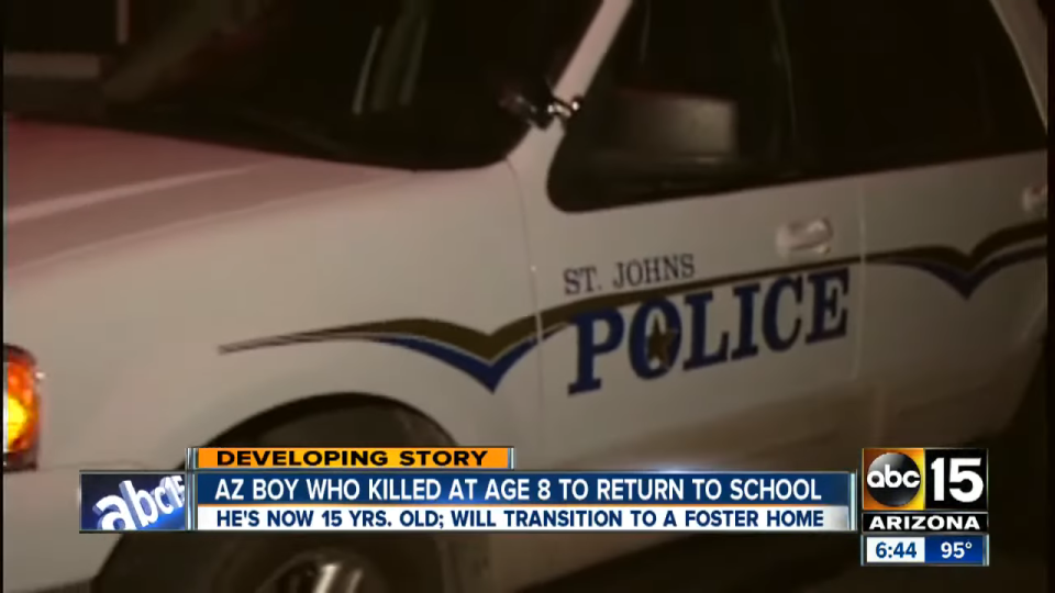 Developing story headline about an Arizona boy who committed homicide at age 8 and is set to return to school at 15, next to a police car