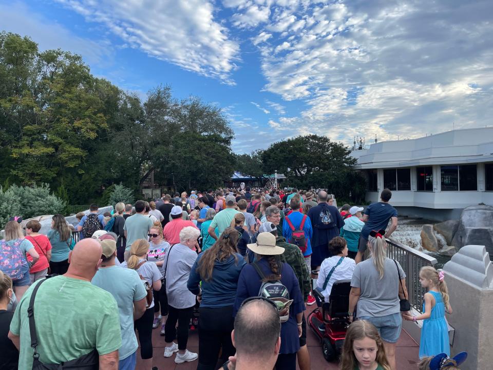 crowds of people on a bridge in magic kingdom during the holidays