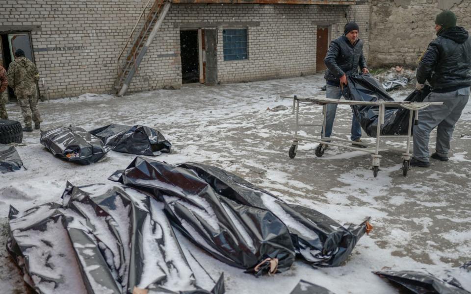Ukrainians transport corpses in body bags in Mykolaiv, a city on the shores of the Black Sea that has been under Russian attack for weeks - BULENT KILIC/AFP via Getty Images