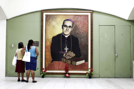 People look at a picture of slain Salvadoran Archbishop Oscar Romero at the national cathedral in San Salvador, El Salvador February 3, 2015. REUTERS/Jose Cabezas