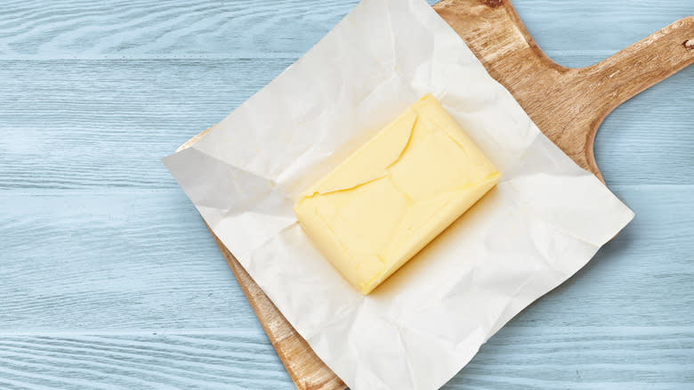 unwrapped block of butter on board