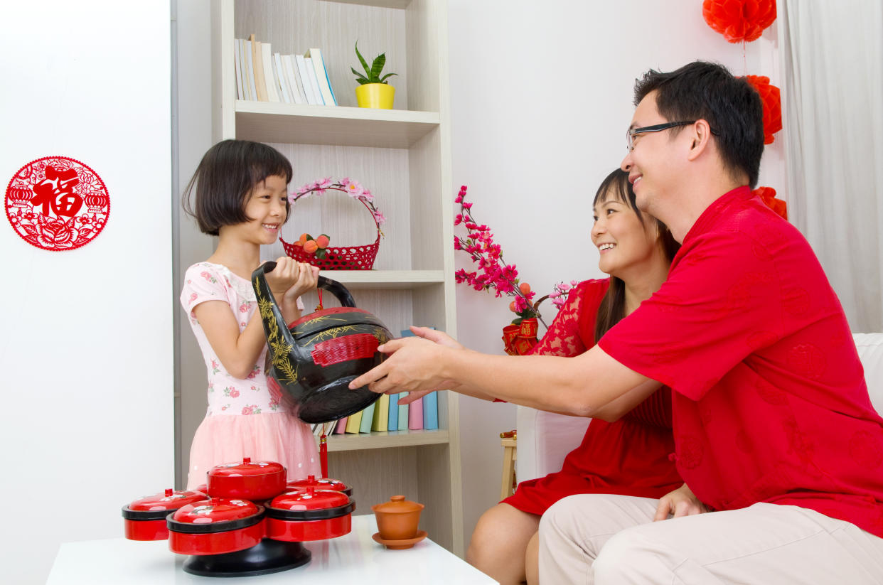 Asian girl presenting gift basket to parents on chinese new year