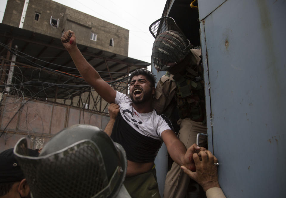 A Kashmiri Shiite Muslim shouts slogans after being detained by police as they attempt to take out a religious procession in Srinagar, Indian controlled Kashmir, Aug. 28, 2020. Police and paramilitary soldiers detained dozens of Muslims participating in religious processions in the Indian portion of Kashmir. Authorities had imposed restrictions in parts of Srinagar, the region's main city, to prevent gatherings marking Muharram from developing into anti-India protests. (AP Photo/Mukhtar Khan)