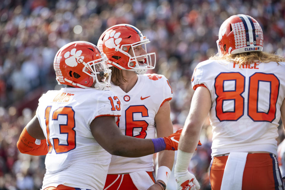 Clemson quarterback Trevor Lawrence (16), Brannon Spector (13), and Luke Price (80) celebrate a touchdown against South Carolina during the first half of an NCAA college football game Saturday, Nov. 30, 2019, in Columbia, S.C. (AP Photo/Sean Rayford)