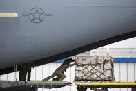 US soldiers unload medical aid from the United States, including ventilators as a donation to help the country tackle the coronavirus outbreak, after a US airforce plane landed at Vnukovo International Airport outside in Moscow, Russia, Thursday, June 4, 2020. (AP Photo/Pavel Golovkin, Pool)