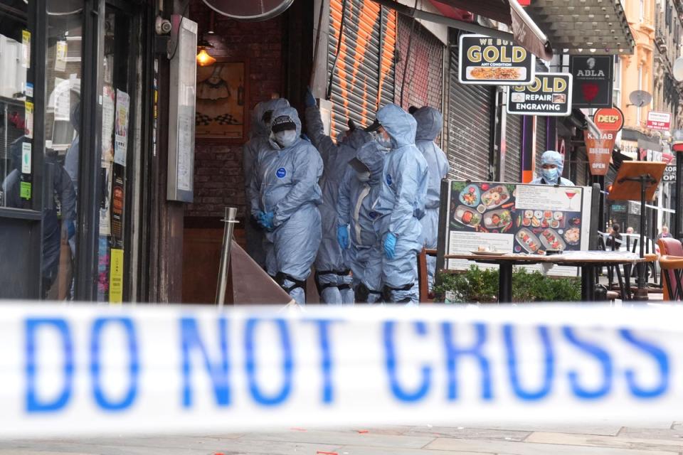 Police forensic officers at the scene of the shooting at Kingsland High Street in Dalston, east London (PA)