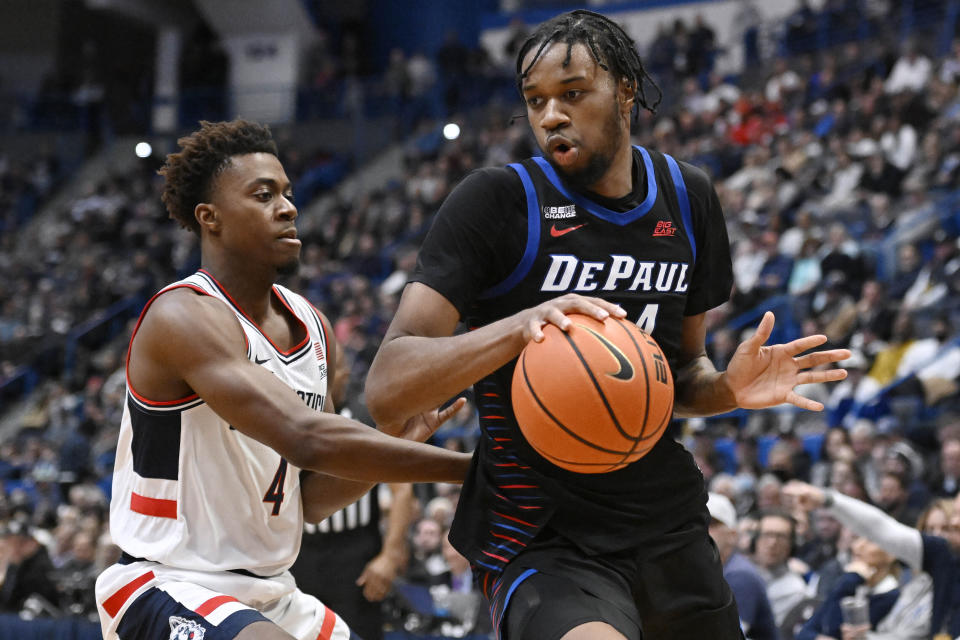 DePaul's Nick Ongenda is guarded by UConn's Nahiem Alleyne (4) in the first half of an NCAA college basketball game, Wednesday, March 1, 2023, in Hartford, Conn. (AP Photo/Jessica Hill)