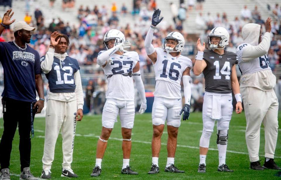 Early enrolled players including Zion Tracy, Lamont Payne Jr., Elliot Washington II and Jaxon Smolik wave to the crowd before the Penn State Blue-White game on Saturday, April 15, 2023.
