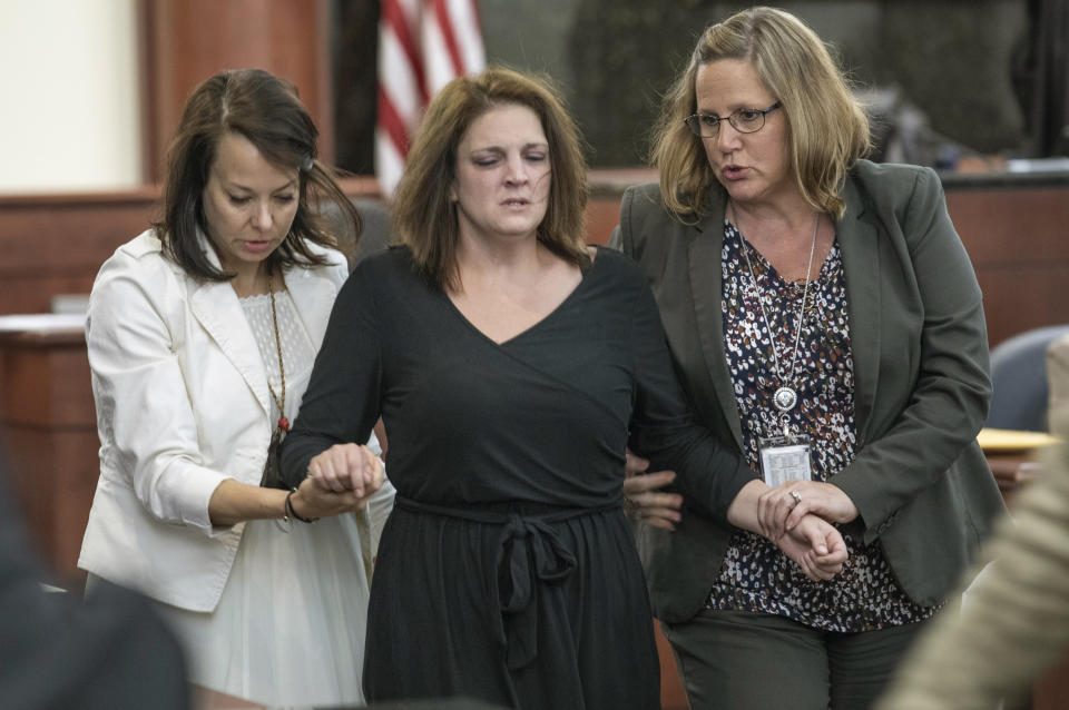 FILE - Amber Kyzer is helped out of the courtroom after breaking down on the witness stand while being questioned during the trial of her ex-husband, Tim Jones, in Columbia, S.C., Monday, May 20, 2019. South Carolina Supreme Court justices are questioning whether a prosecutor offered to show photos of five dead children to a jury to unfairly upset them so they would sentence their father to death. The high court heard 39-year-old Timothy Jones' request to overturn his murder convictions and death sentence on Tuesday, Nov. 9, 2021. (Tracy Glantz/The State via AP, Pool, File)