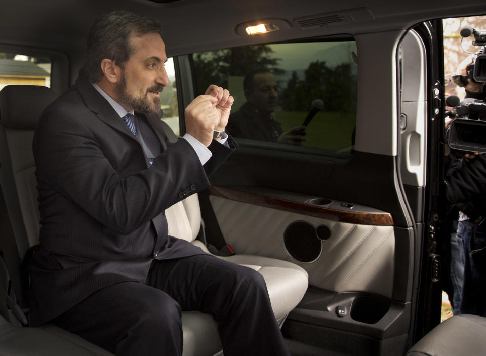 Louay Safi, spokesperson for the Syrian National Coalition, Syria's main political opposition group, gestures as he answers journalists' questions while sitting in his car to leave the United Nations headquarters in Geneva, Switzerland, Wednesday, Jan. 29, 2014. Syrian negotiators have resumed talks over the country's future a day after cutting short their discussions over a U.S. decision to resume aid to the opposition. (AP Photo/Anja Niedringhaus)