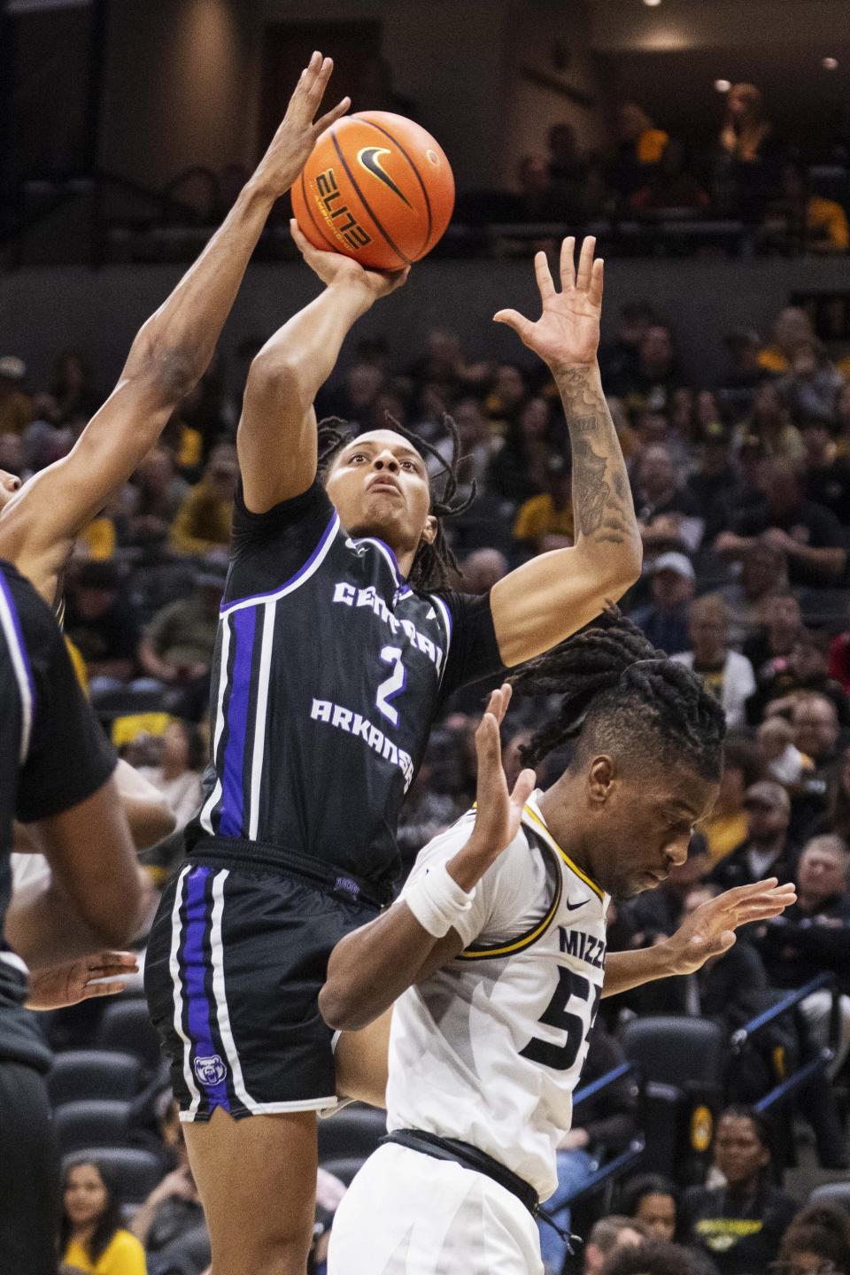 Central Arkansas' Javion Guy-King, top, shoots over Missouri's Sean East II, right, during the first half of an NCAA college basketball game Saturday, Dec. 30, 2023, in Columbia, Mo. (AP Photo/L.G. Patterson)