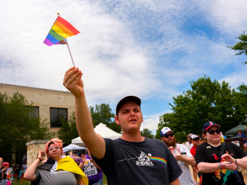 Anthony Trefny waves an LGBTQ pride flag during the first Round Rock Pride Festival at Centennial Plaza on Saturday. The event is one of several inaugural Pride celebrations in Central Texas this year, joining towns like Pflugerville and Leander.