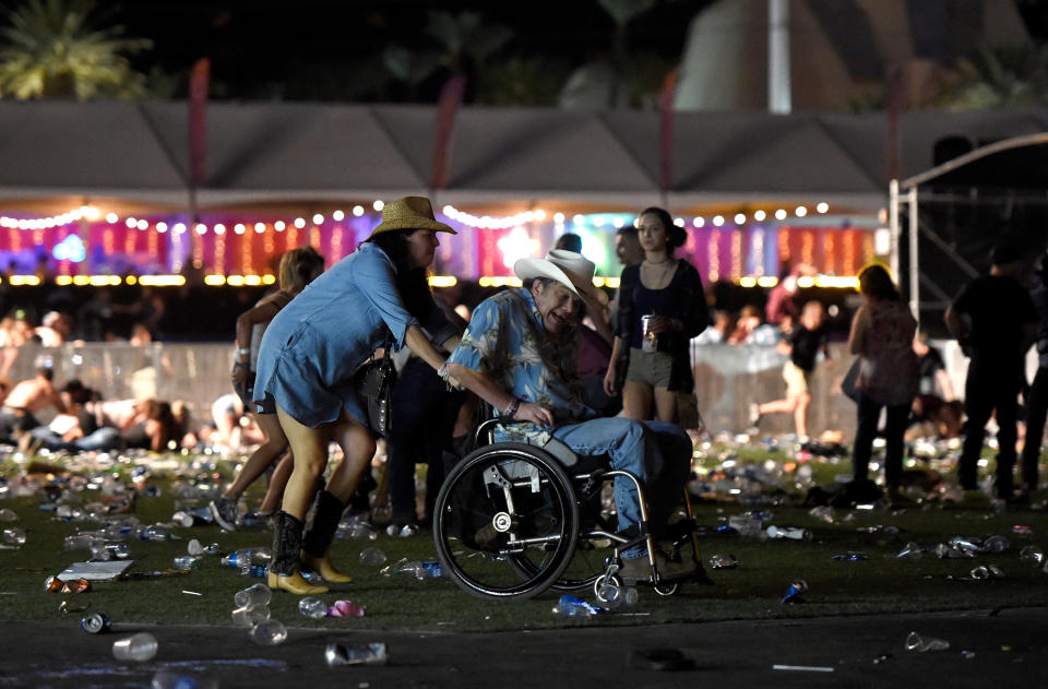 A man in a wheelchair is&nbsp;helped away.