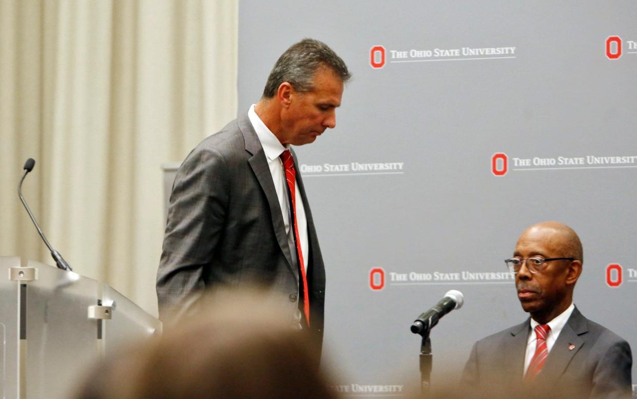 OSU football coach Urban Meyer walks past OSU president Michael Drake after talking to the media in regards to his suspension August 22, 2018. [Eric Albrecht/Dispatch]
