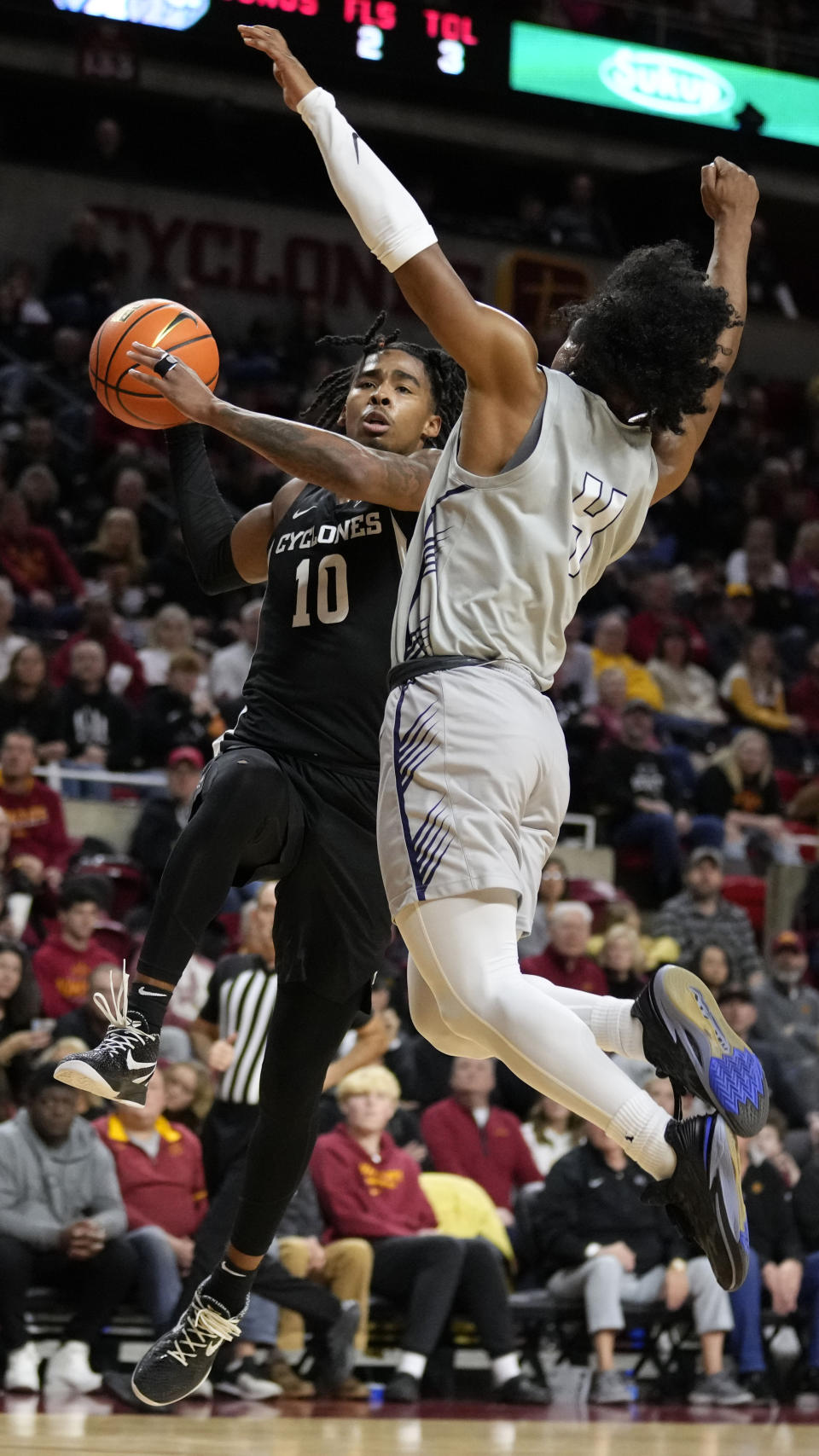 Iowa State guard Keshon Gilbert (10) is fouled by New Hampshire guard Ahmad Robinson (4) during the second half of an NCAA college basketball game, Sunday, Dec. 31, 2023, in Ames, Iowa. (AP Photo/Charlie Neibergall)
