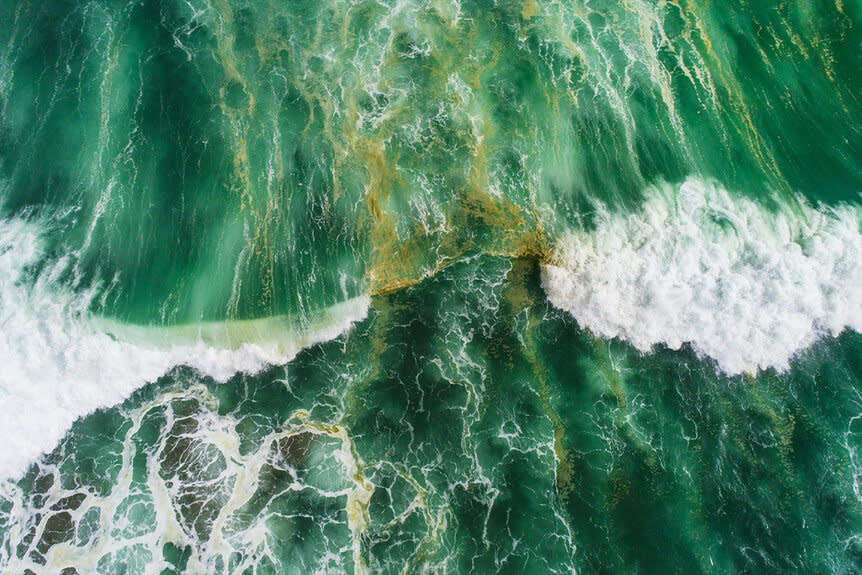 Aerial view of waves splashing in sea.