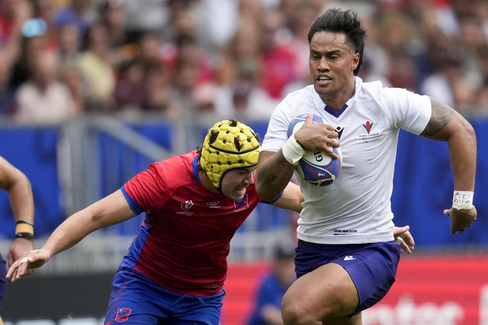 Samoa's Ulupano Junior Seuteni, right, is about to be tackled by Chile's Matias Garafulic during the Rugby World Cup Pool D match between Samoa and Chile at the Stade de Bordeaux in Bordeaux, France, Saturday, Sept. 16, 2023. (AP Photo/Christophe Ena)